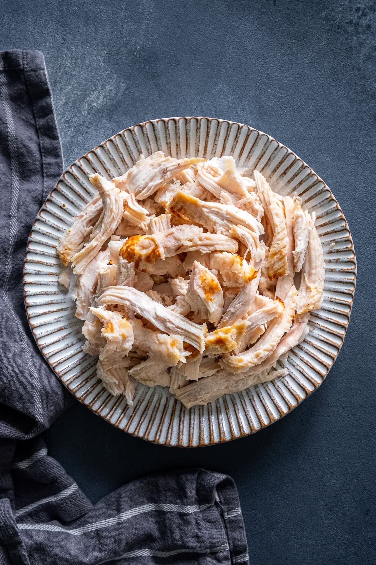 Overhead shot of a plateful of shredded cooked turkey.