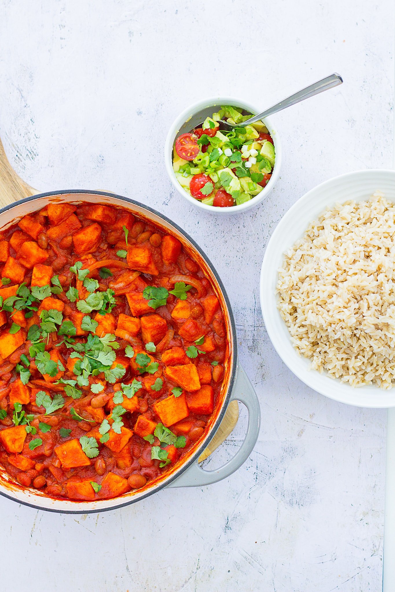 Overhead shot of Easy Sweet Potato Chilli with avocado salad and brown rice