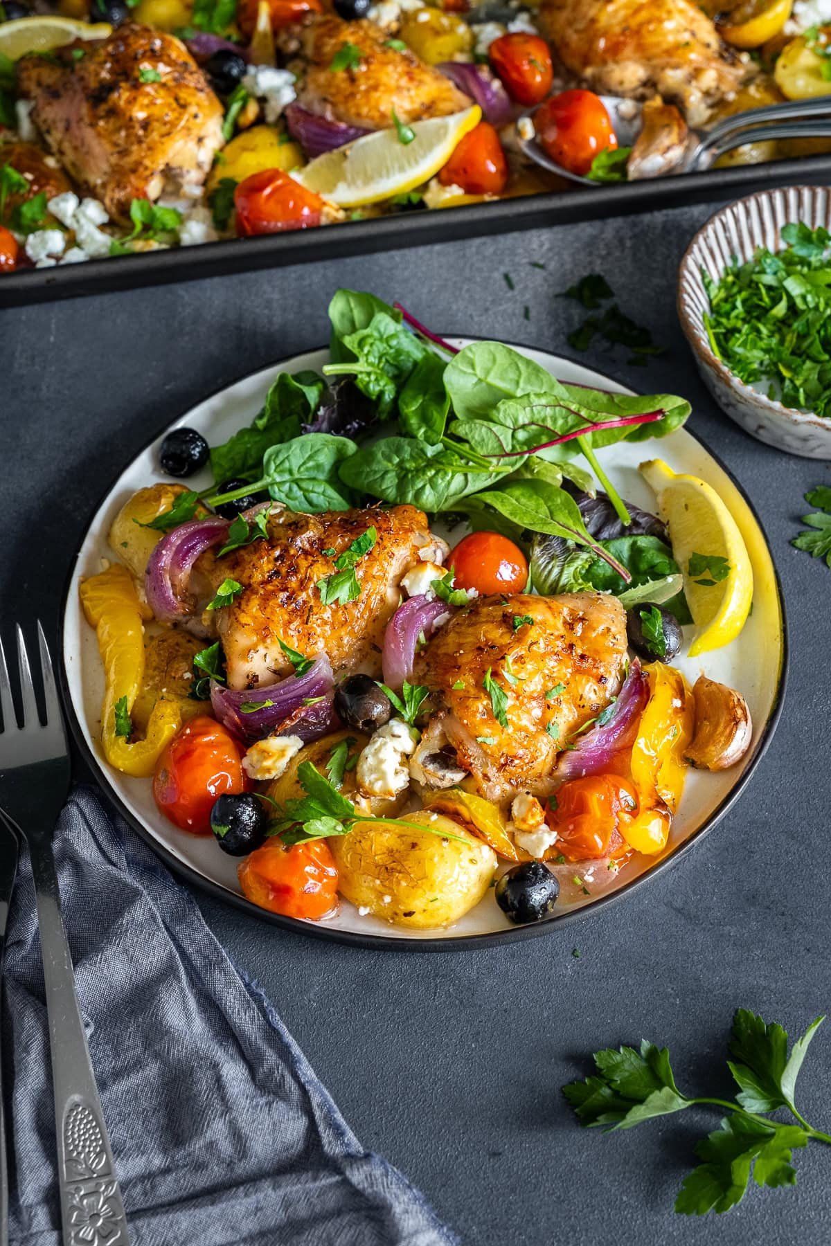 Greek Chicken Traybake on a plate with salad.