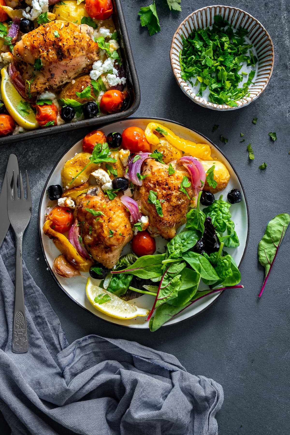 Overhead shot of Greek Chicken Traybake on a plate with salad.