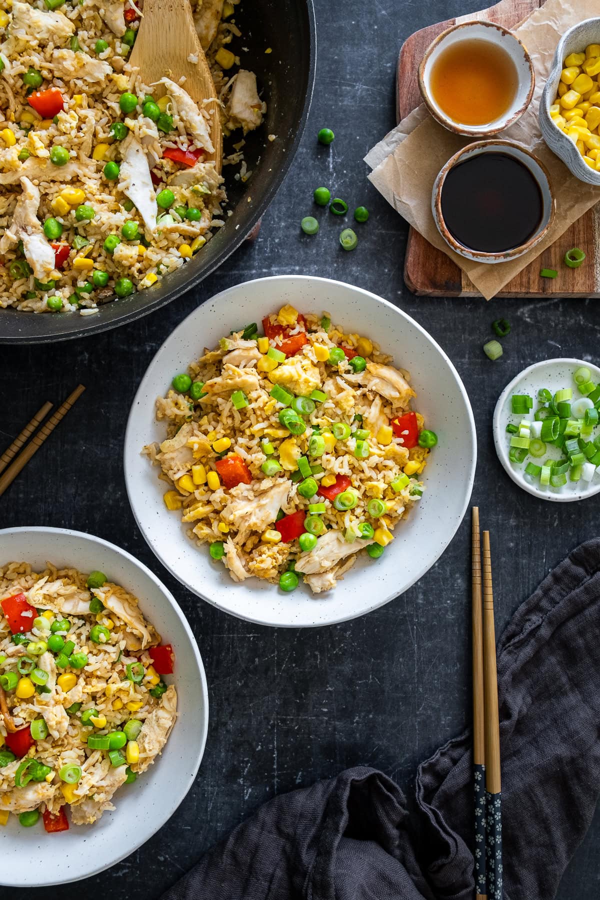 Overhead shot of Chicken Fried Rice in the pan and 2 bowls.