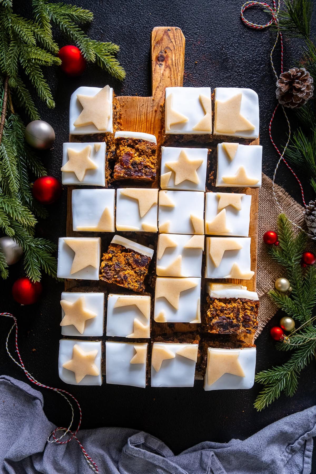 Easy Christmas Cake Traybake cut into slices, some of the slices are turned over to reveal the inside of the cake.