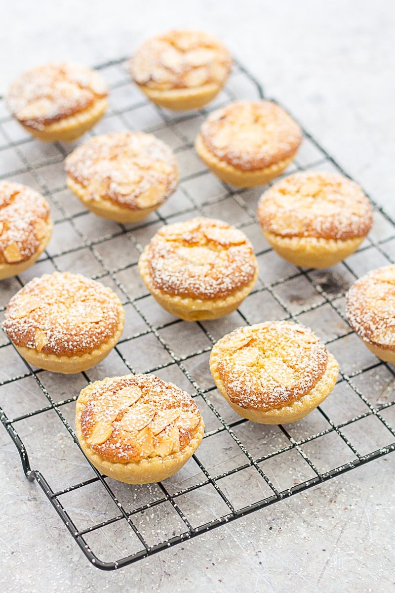 Easy Frangipane Topped Mince Pies on a cooling rack, having just been dusted with icing sugar