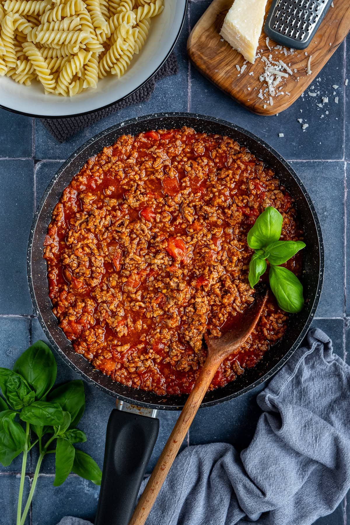 Overhead shot of bolognese sauce in the pan, with basil.