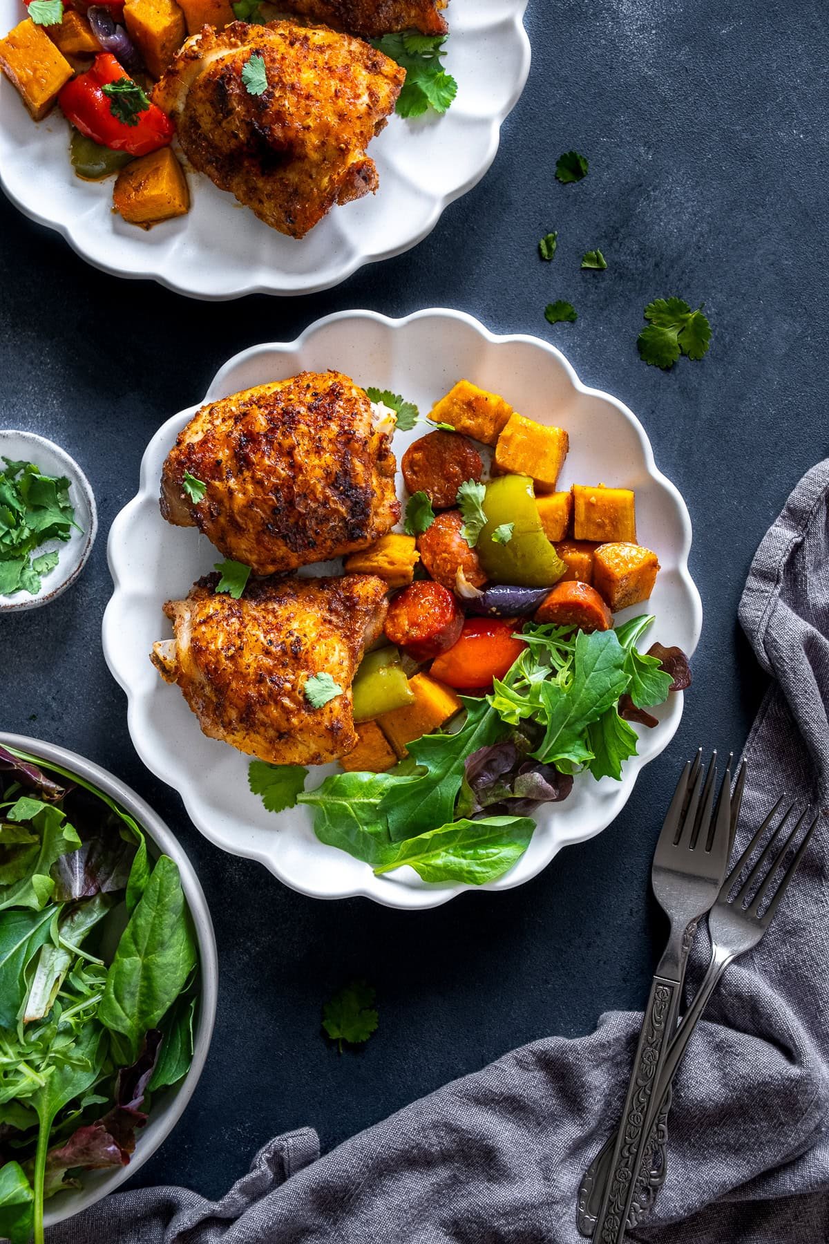 Overhead shot of Cajun Chicken Traybake on a plate with salad.