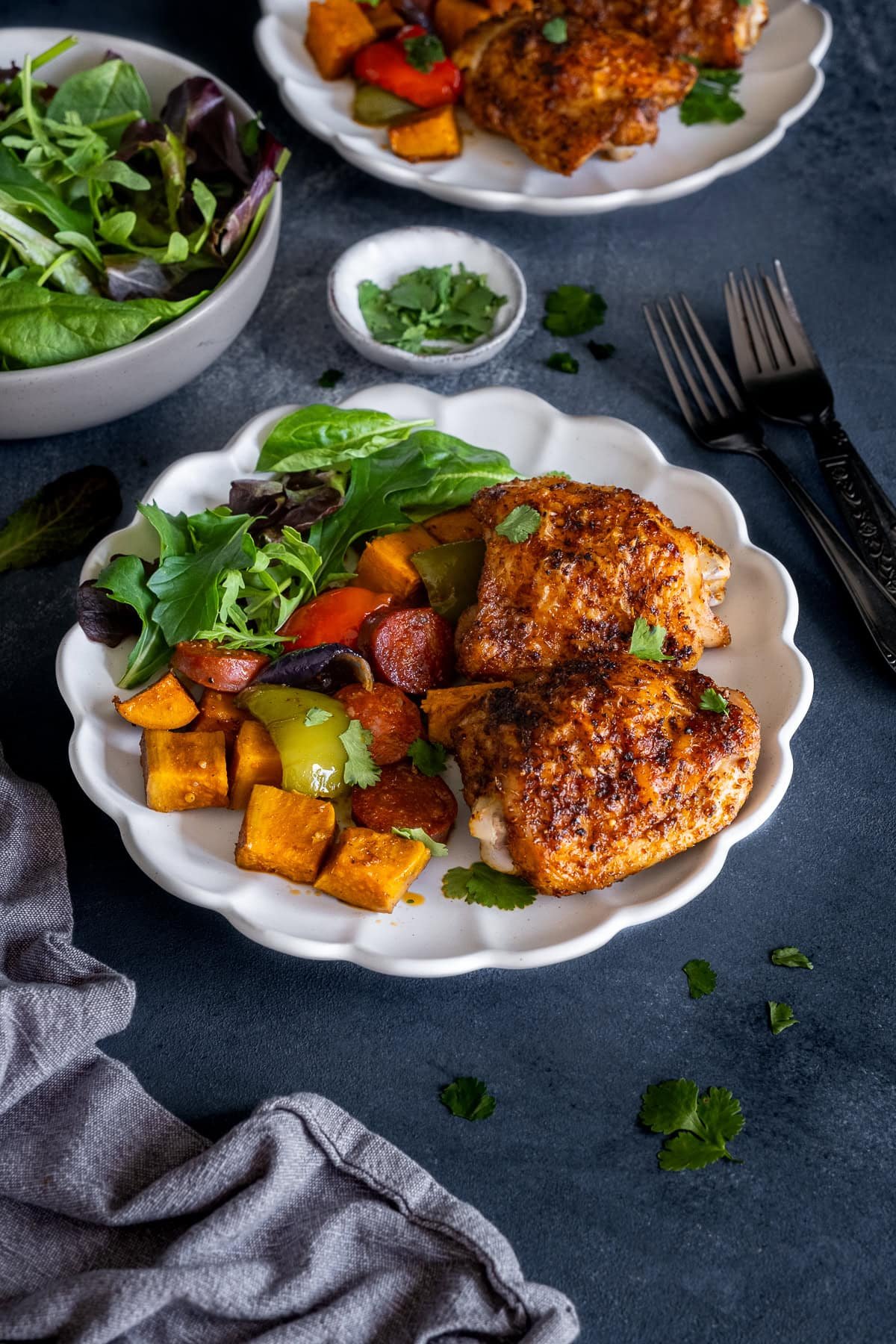 Closeup of Cajun Chicken Traybake on a plate with salad.