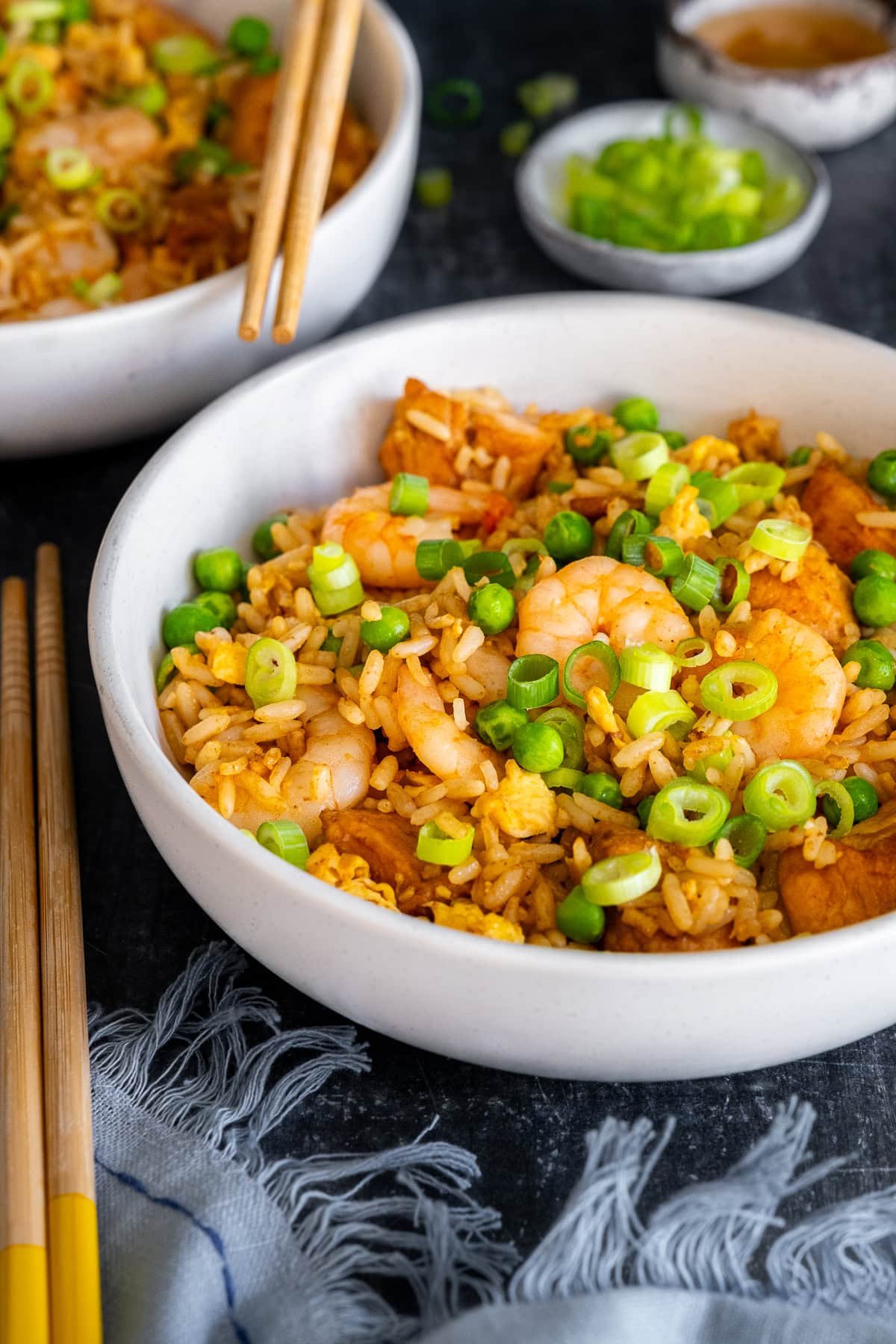 Closeup of Chicken and Prawn Fried Rice in a bowl with chopsticks.