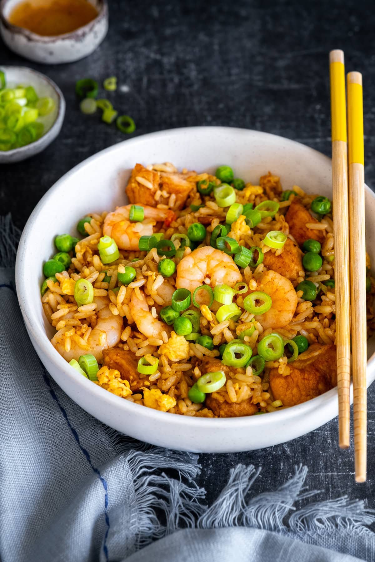 Closeup of Chicken and Prawn Fried Rice in a bowl with chopsticks.