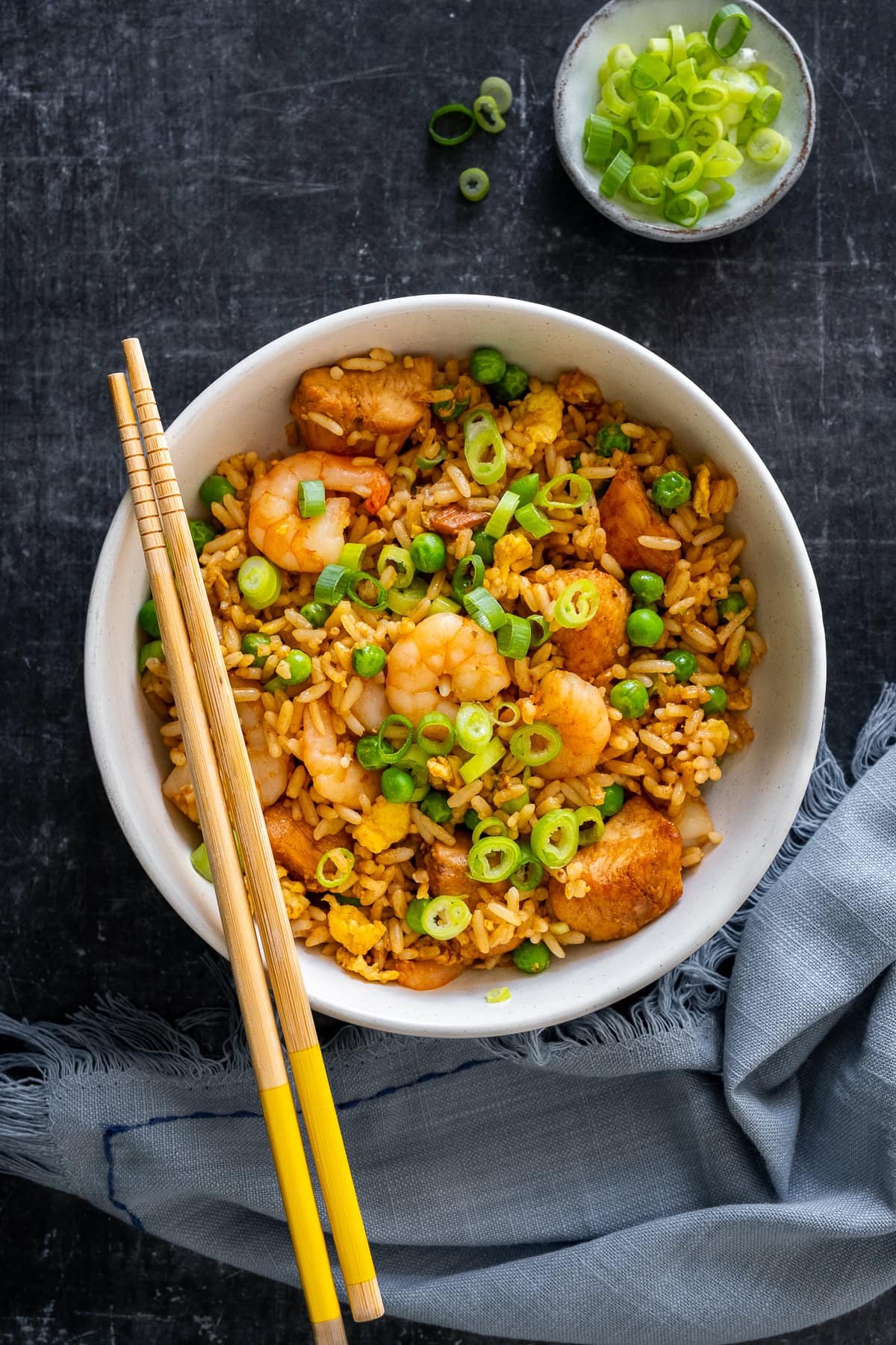 Overhead shot of Chicken and Prawn Fried Rice in a bowl with chopsticks.