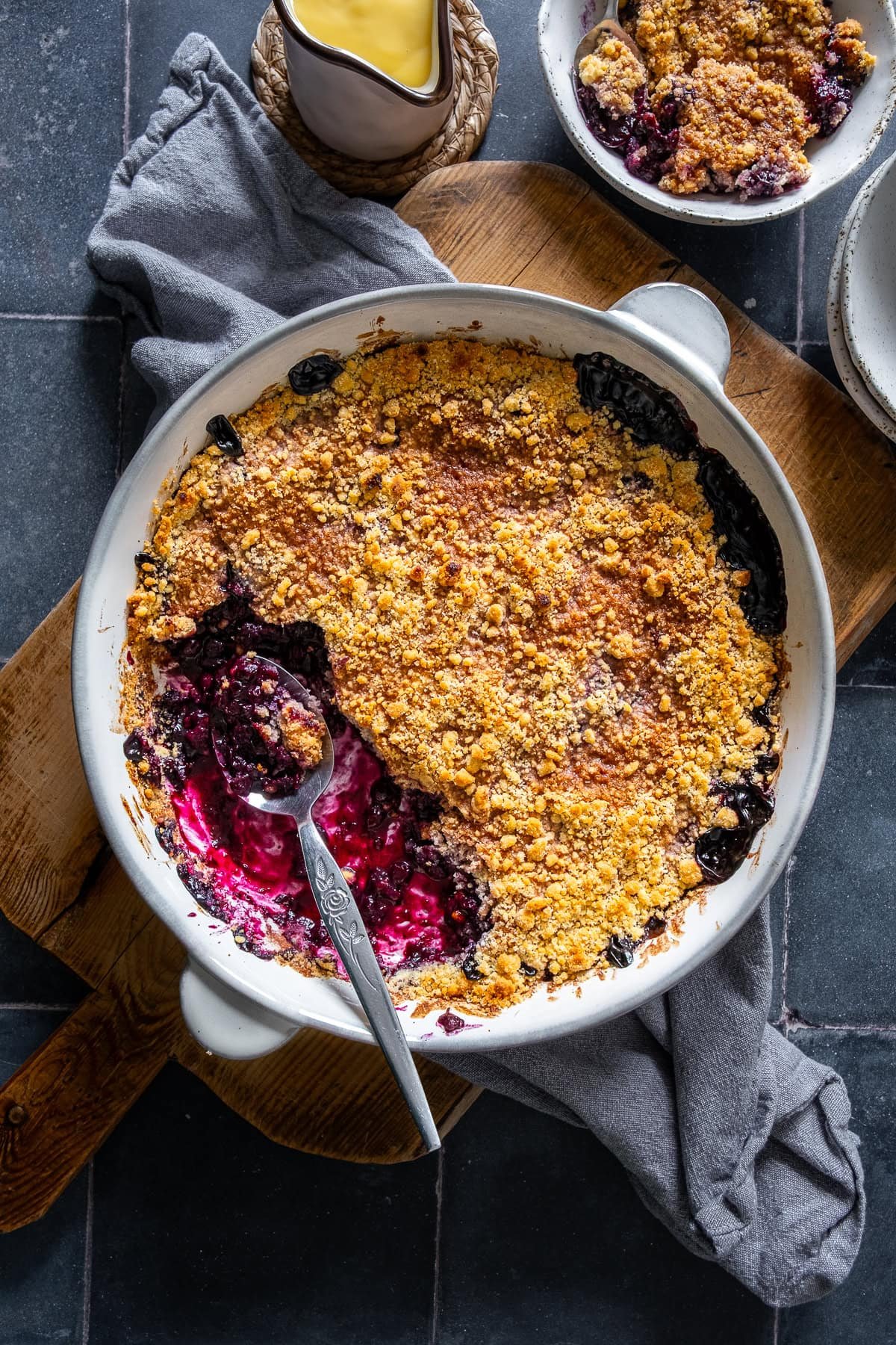 Overhead shot of Easy Blueberry Crumble in the oven dish. One portion has been taken out.