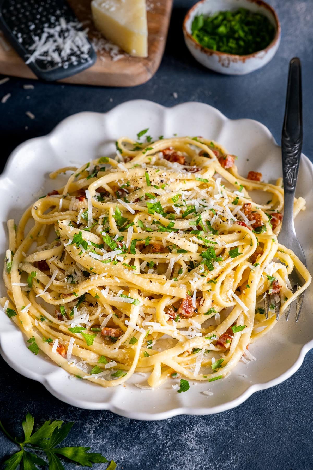 Closeupf of Easy Creamy Carbonara on a plate with grated parmesan on top.