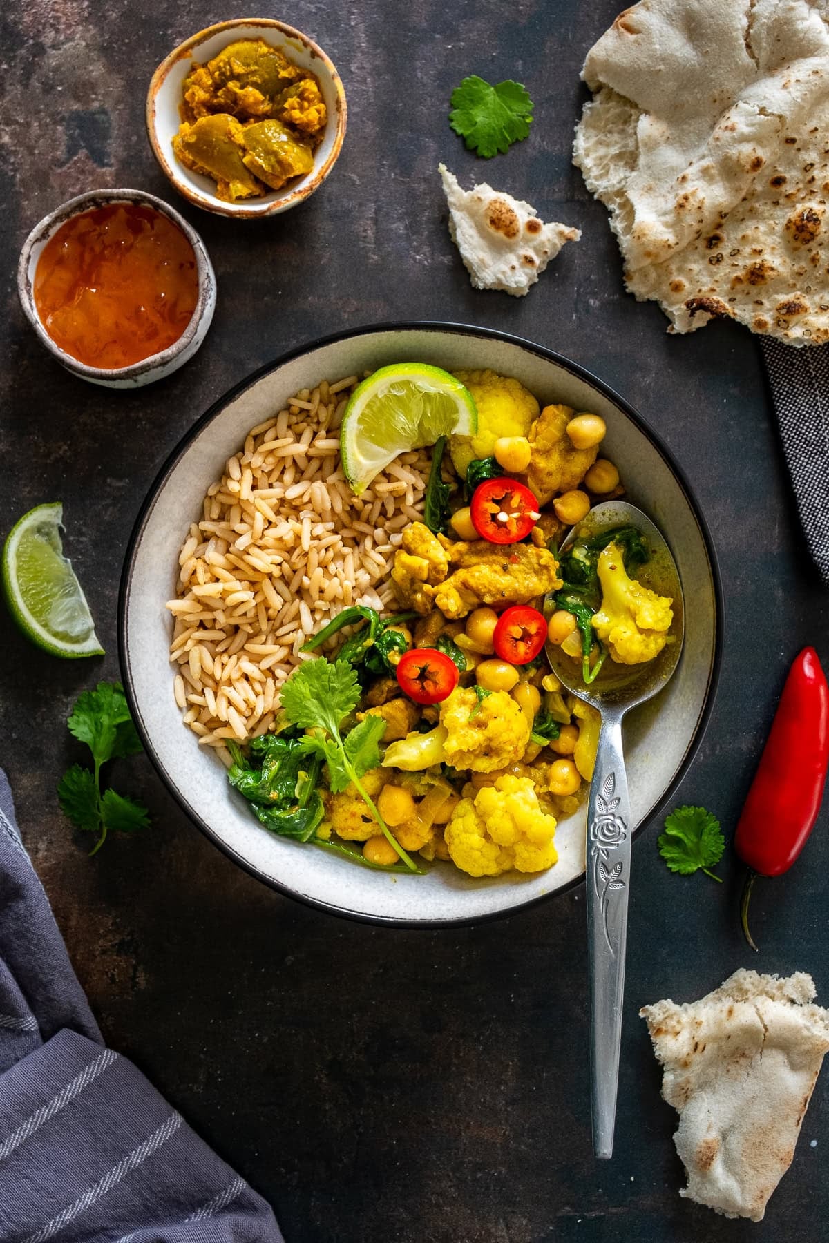 Overhead shot of Chicken and Chickpea Curry with Spinach in a bowl with brown rice.