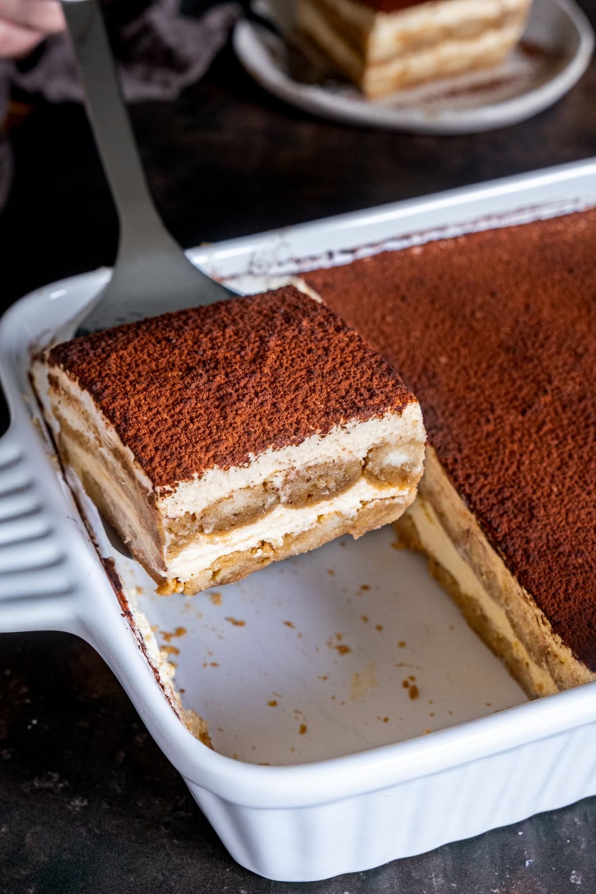 Easy Baileys Tiramisù in the dish, once slice is being lifted out with a fish slice.