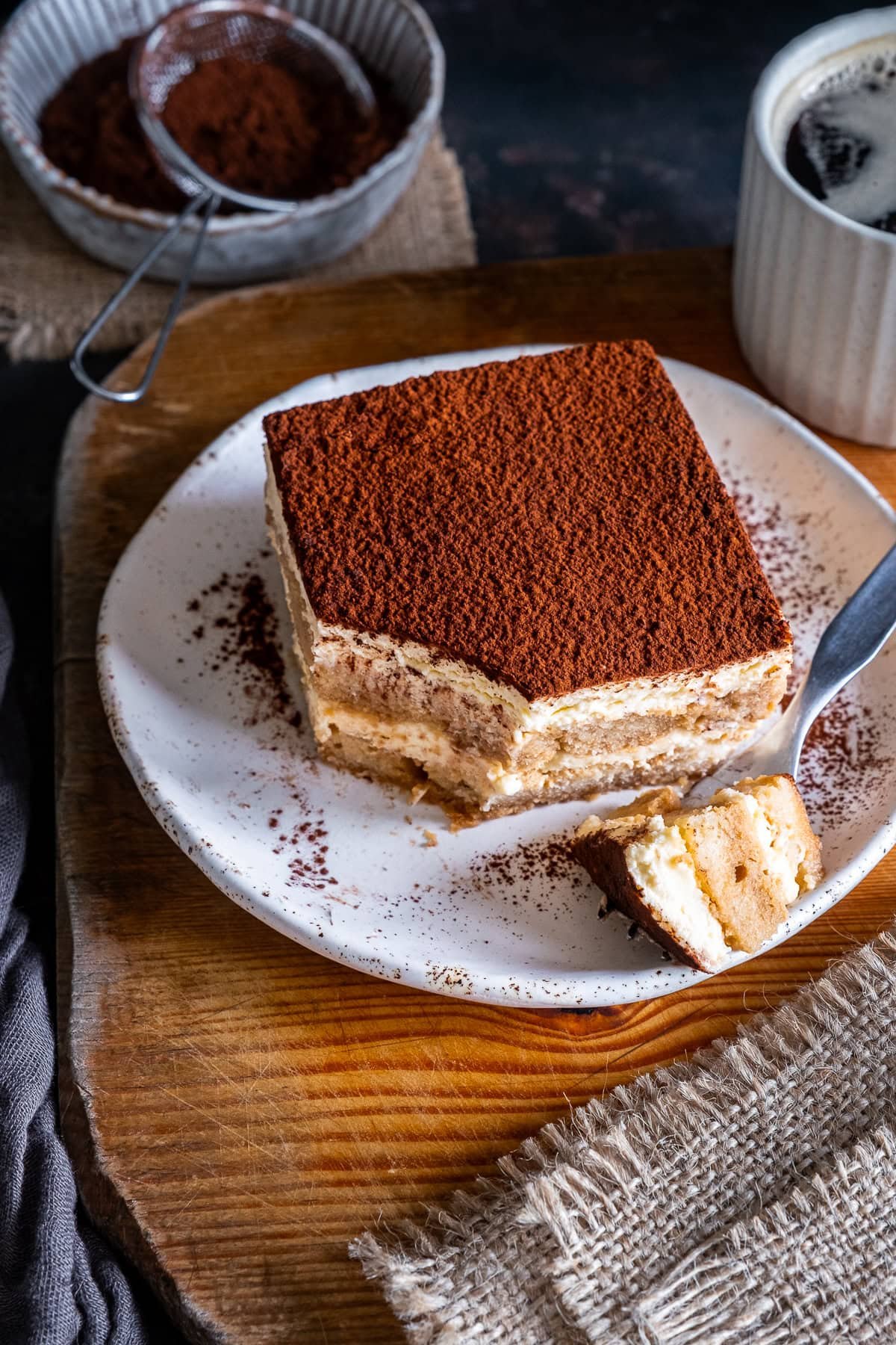 Once piece of Easy Baileys Tiramisù on a plate, a small corner has been taken off with a fork.