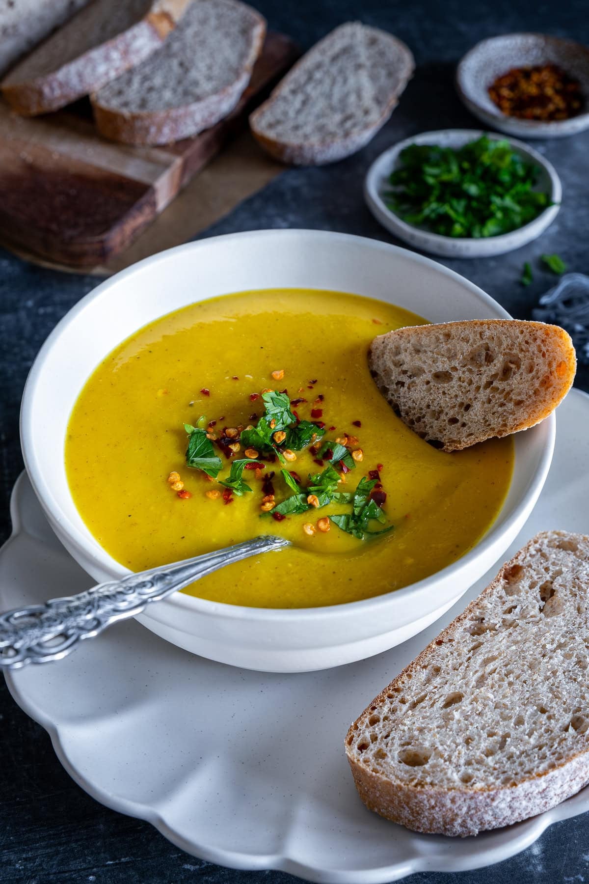 Closeup of Easy Roasted Parsnip Soup in a bowl with bread on the side.