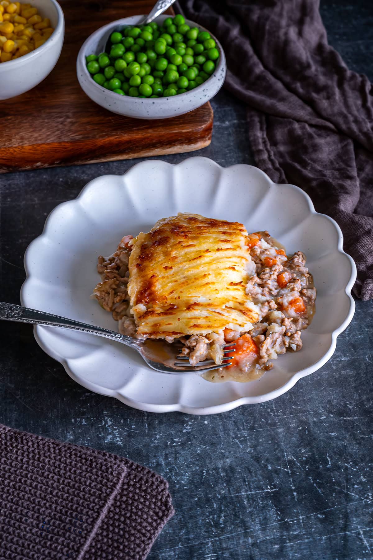 Easy Peasy Shepherd’s Pie on a plate with sweetcorn and peas.