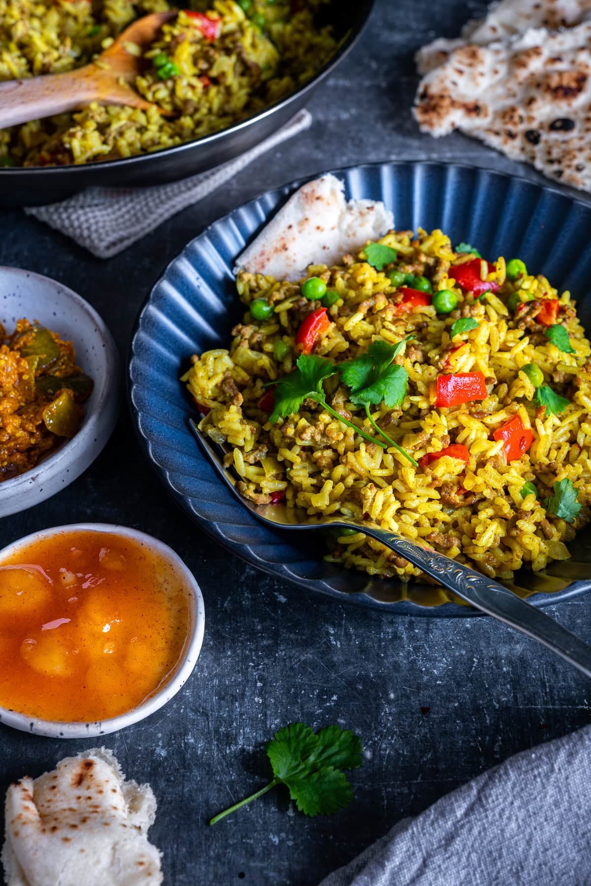 Easy Beef Biryani in a bowl with naan and mango chutney.