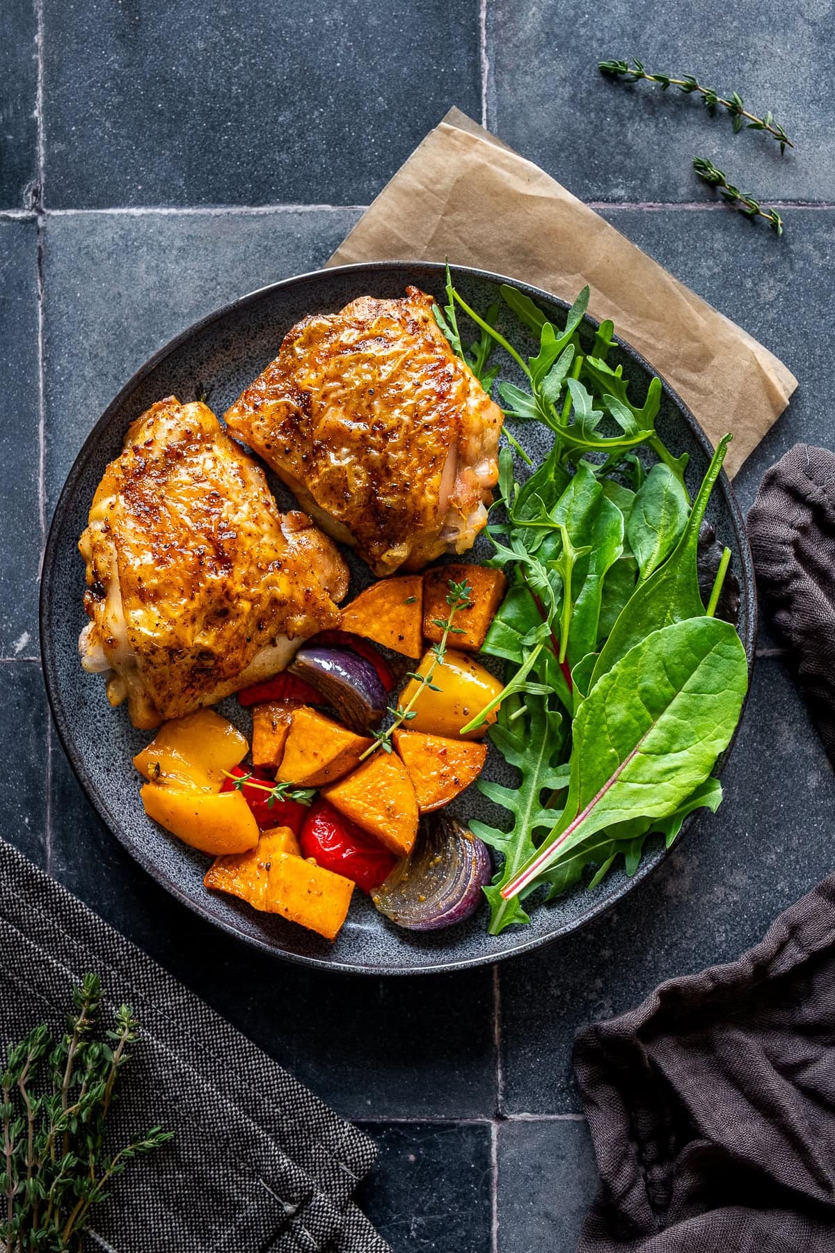 Easy Chicken Thigh Traybake on a plate with salad.