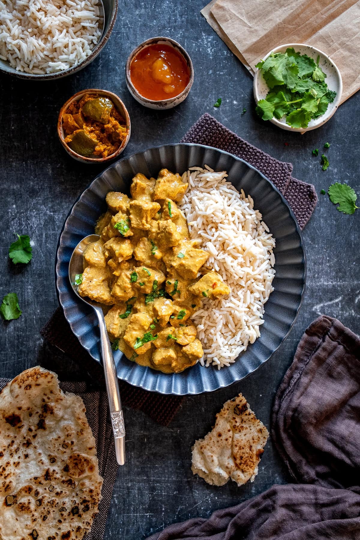 Overhead shot of Easy Lamb Korma surrounded by side dishes.