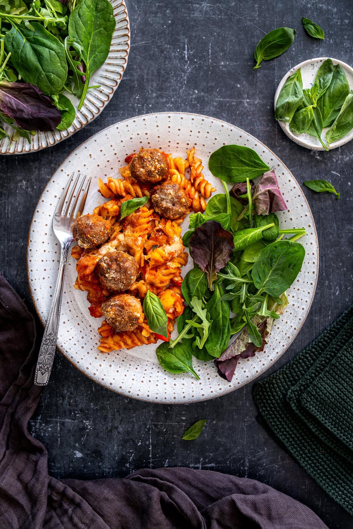 Overhead shot of Easy Meatball Pasta Bake on a plate with a side salad.