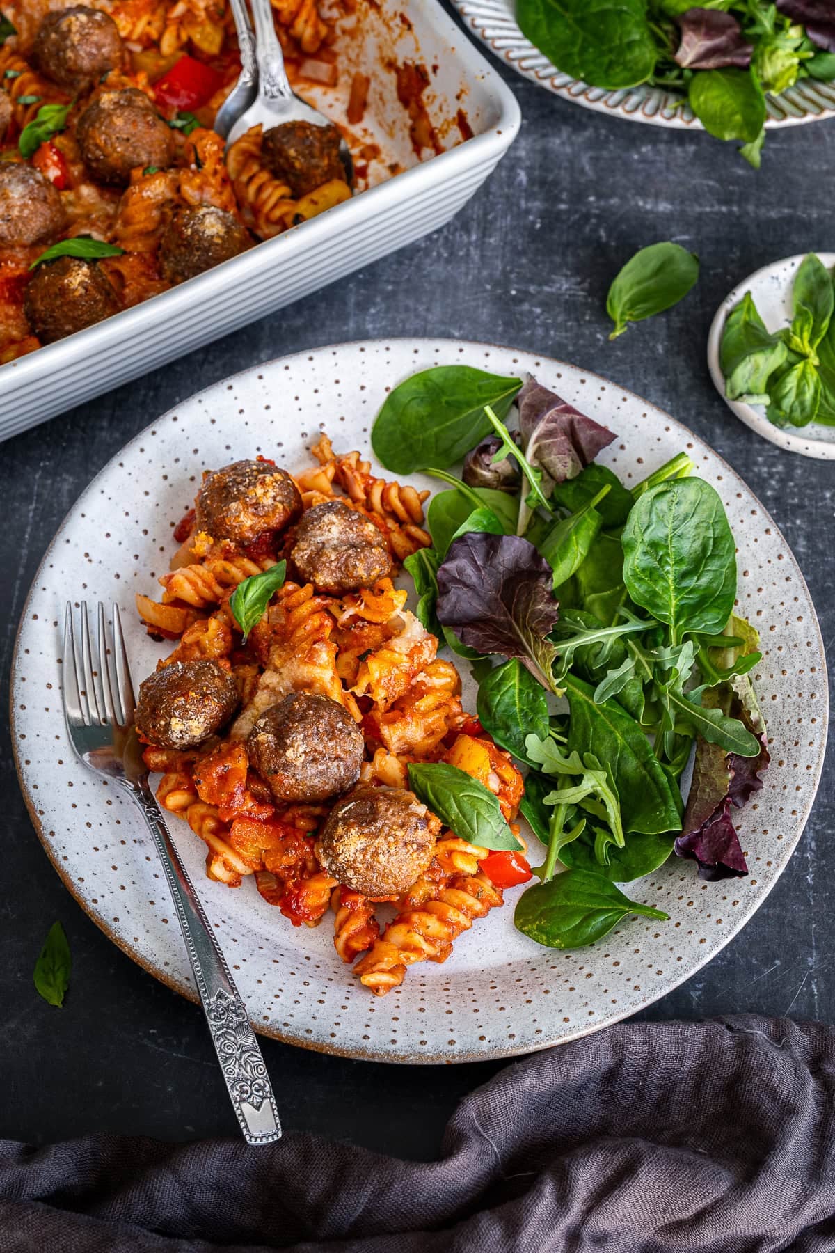 Easy Meatball Pasta Bake on a plate with a side salad.