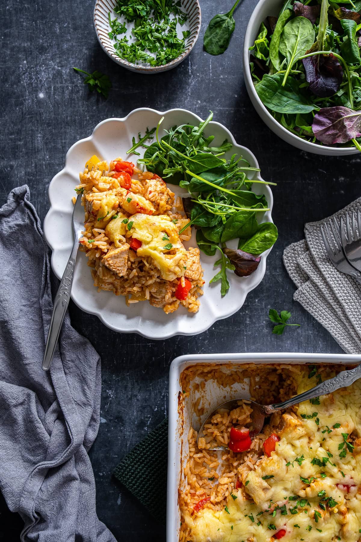Overhead shot of Chicken Fajita Rice Bake on a plate with salad.
