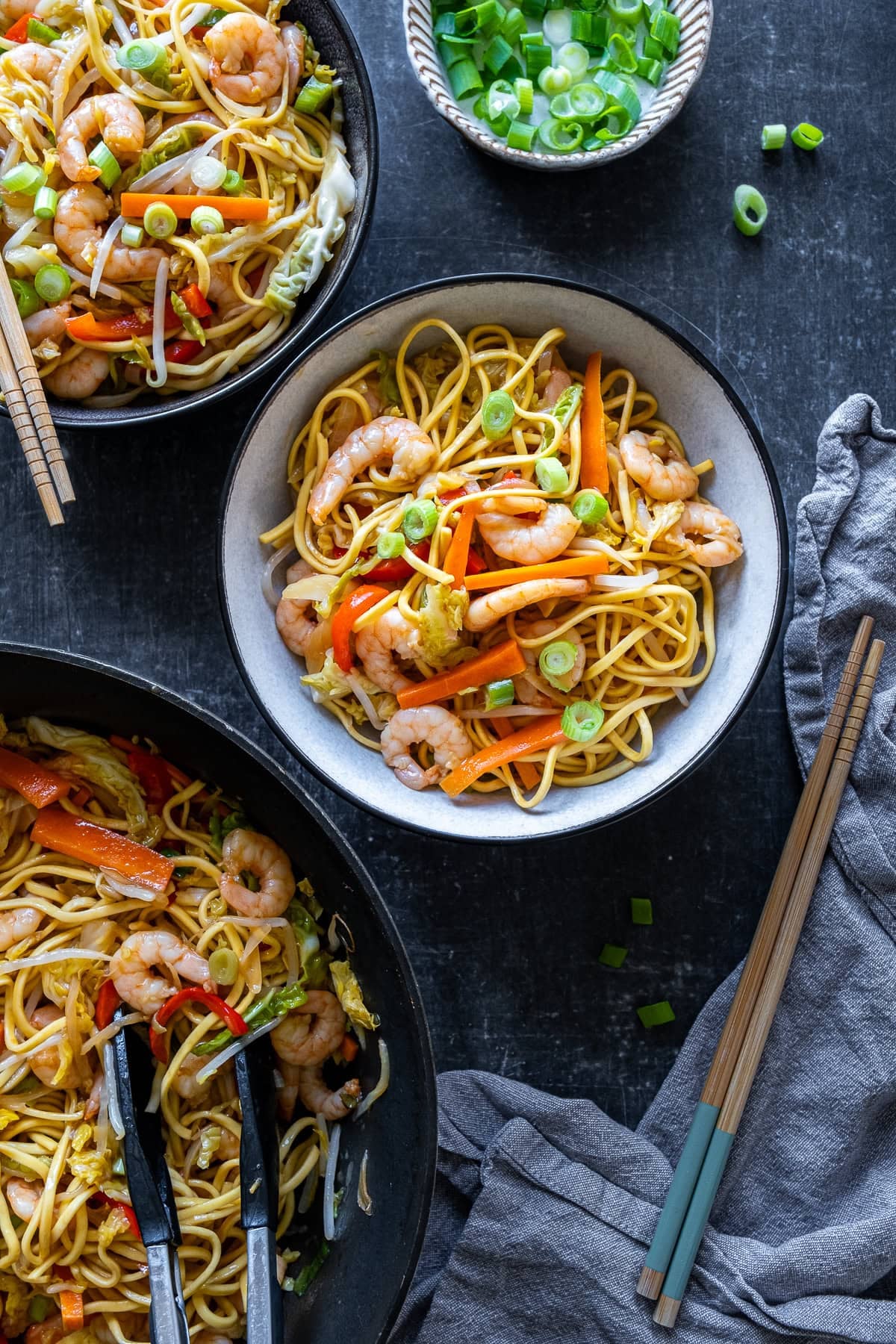 Easy Prawn Chow Mein in a bowl next to another bowl of Easy Prawn Chow Mein and the wok.