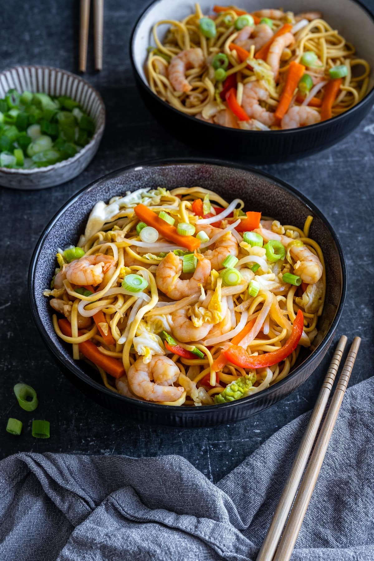 Closeup of 1 bowl of Prawn Chow Mein, a second bowlful is in the background.
