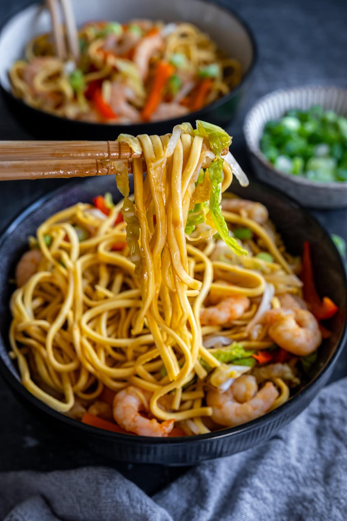 Prawn Chow Mein noodles being lifted up with chopsticks.