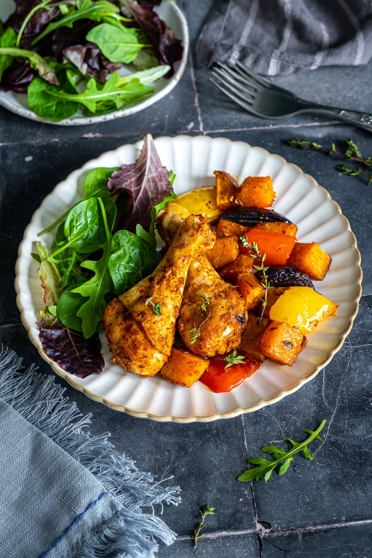 Closeup of Chicken Drumstick Traybake on a plate with salad.