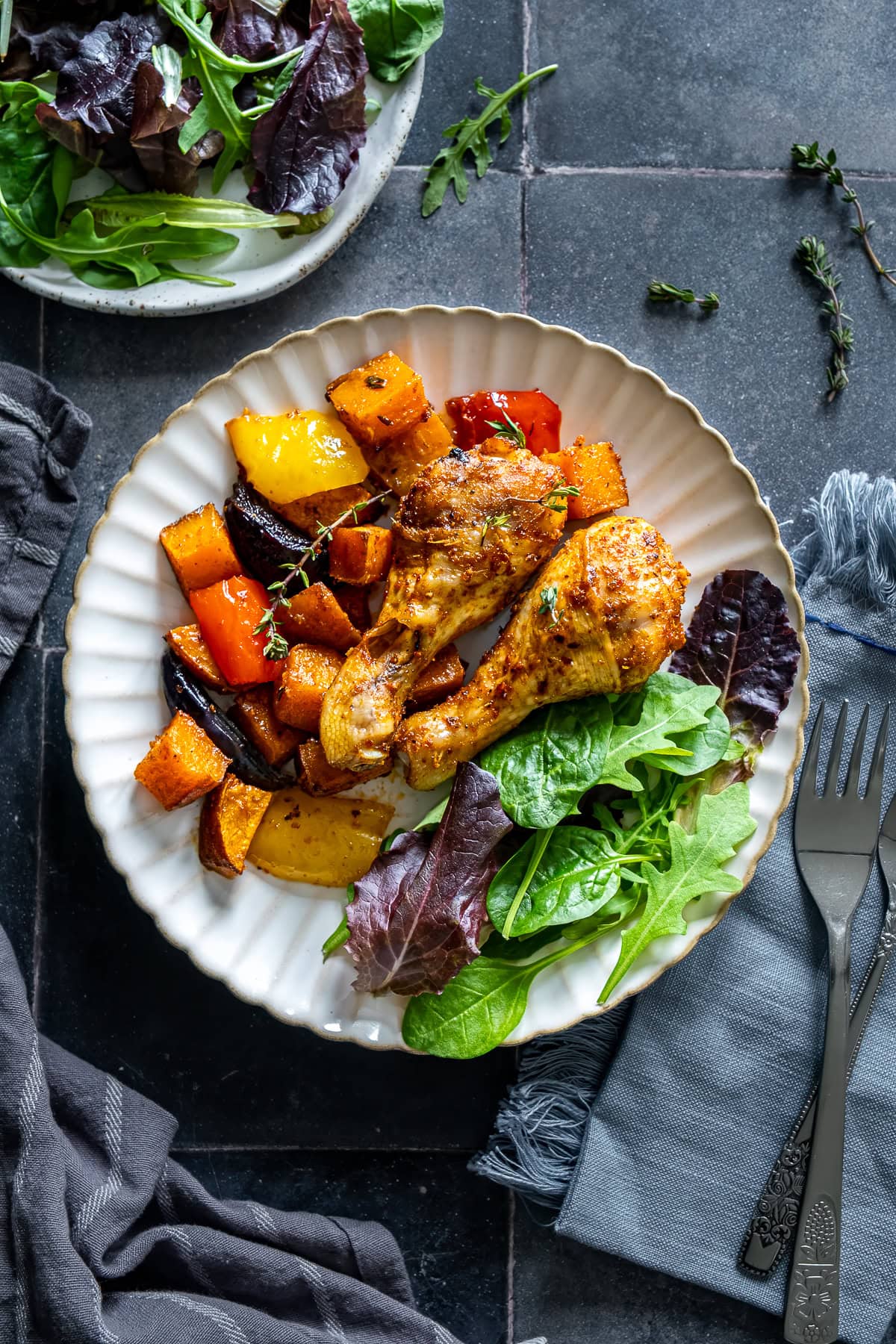 Overhead shot of Chicken Drumstick Traybake on a plate with salad leaves.