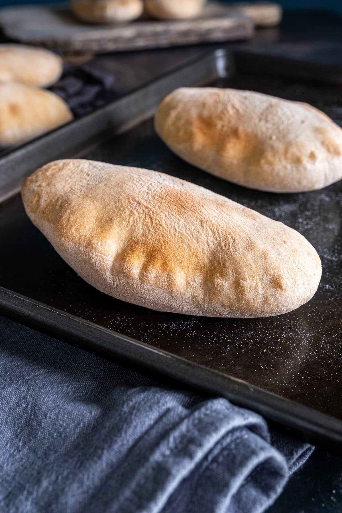 2 perfectly puffed pittas on a baking sheet.