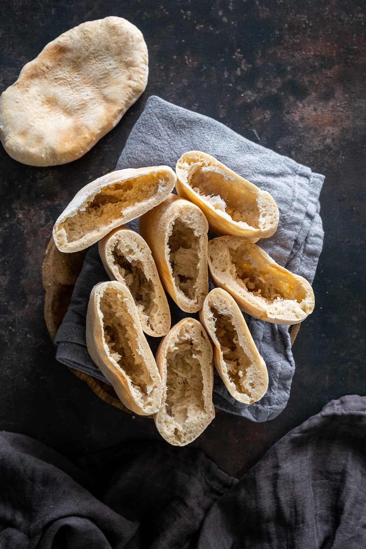 Overhead shot of 4 Easy Homemade Pittas cut to reveal a perfect pocket inside.