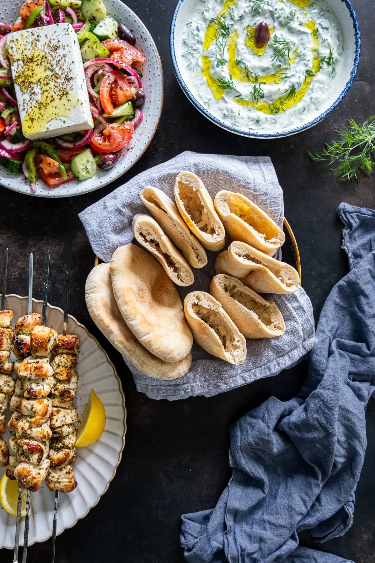 Overhead shot of Easy Homemade Pittas, many cut to reveal a perfect pocket inside.