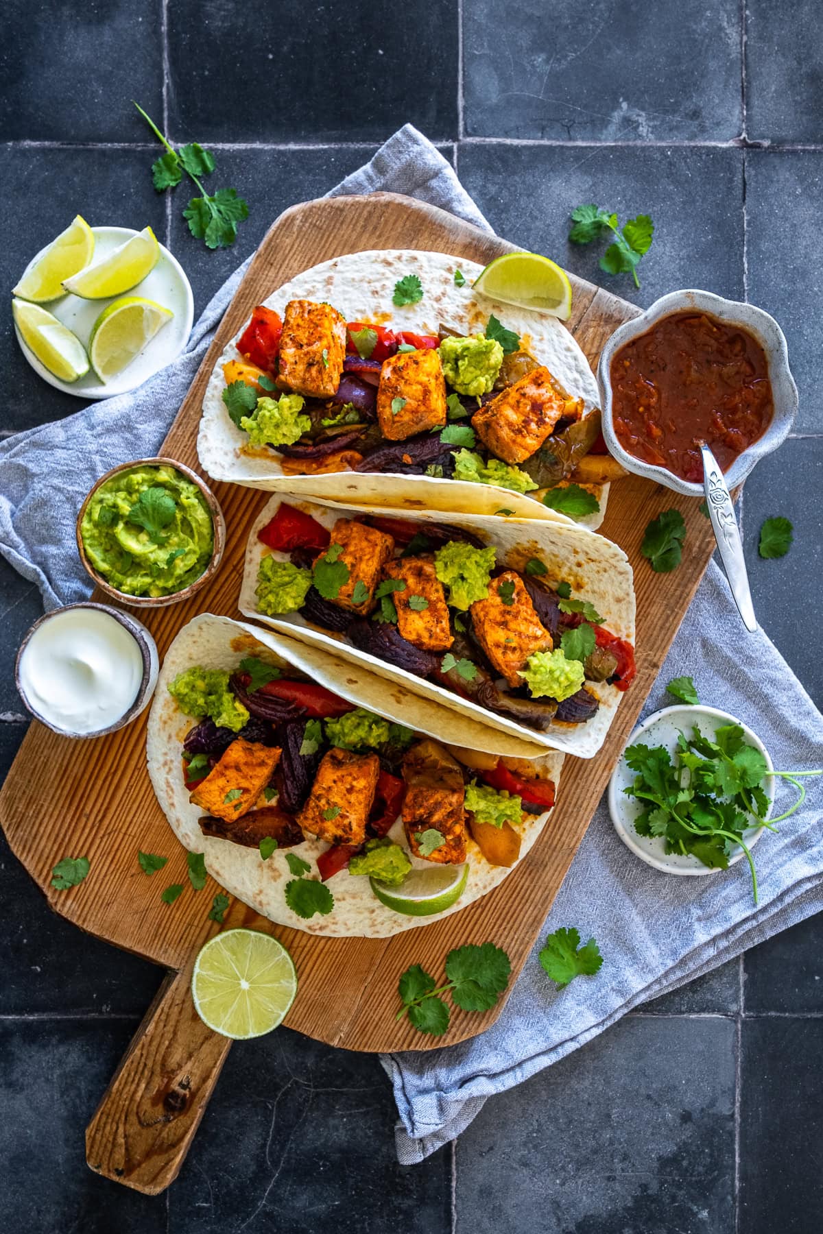 Overhead shot of 3 Salmon Fajitas on a board.