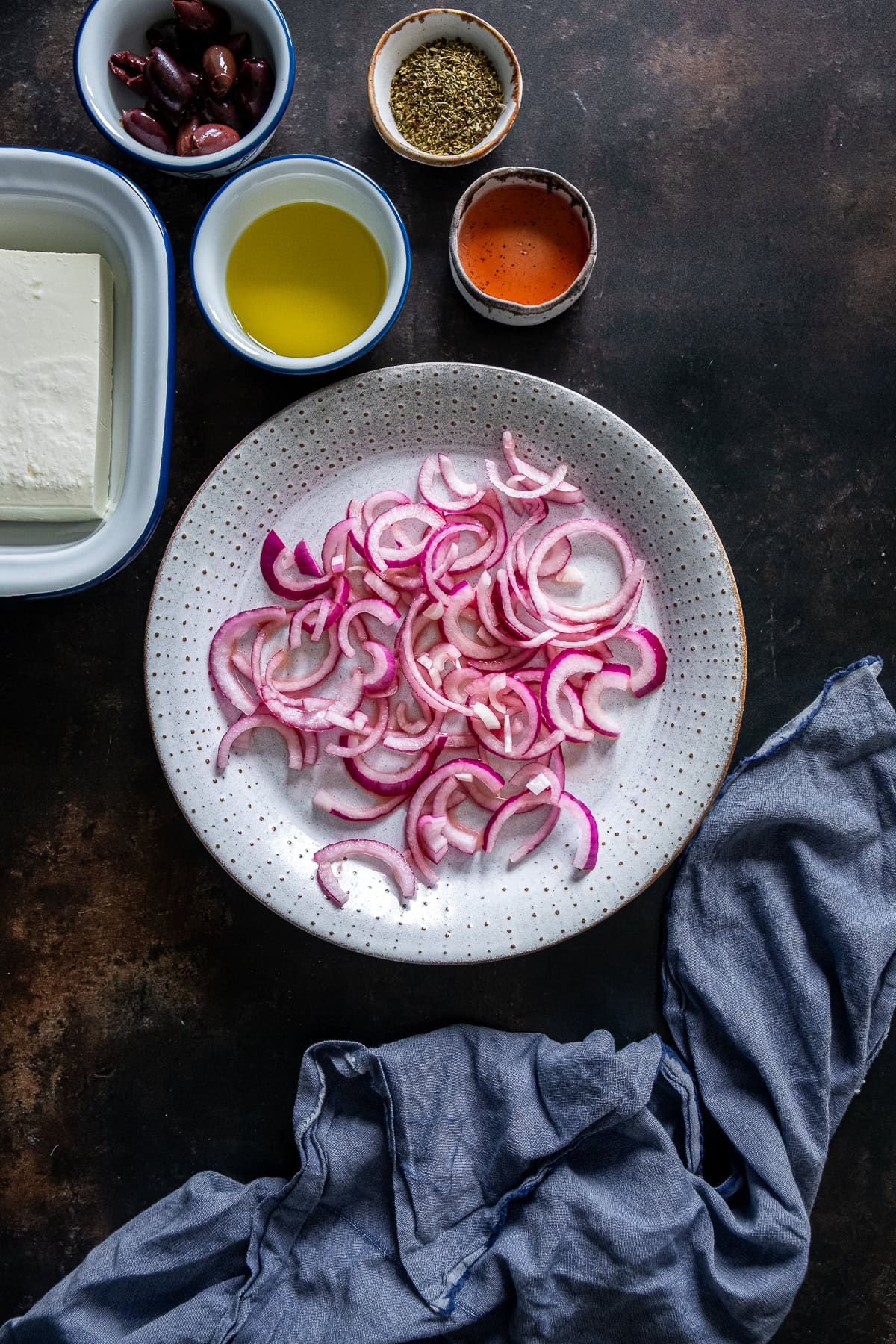 Shot of red onions macerating in red wine vinegar for Authentic Greek Salad (Horiátiki Salata)