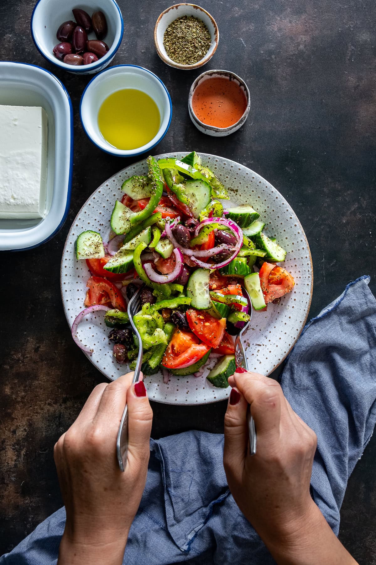 Authentic Greek Salad being mixed.