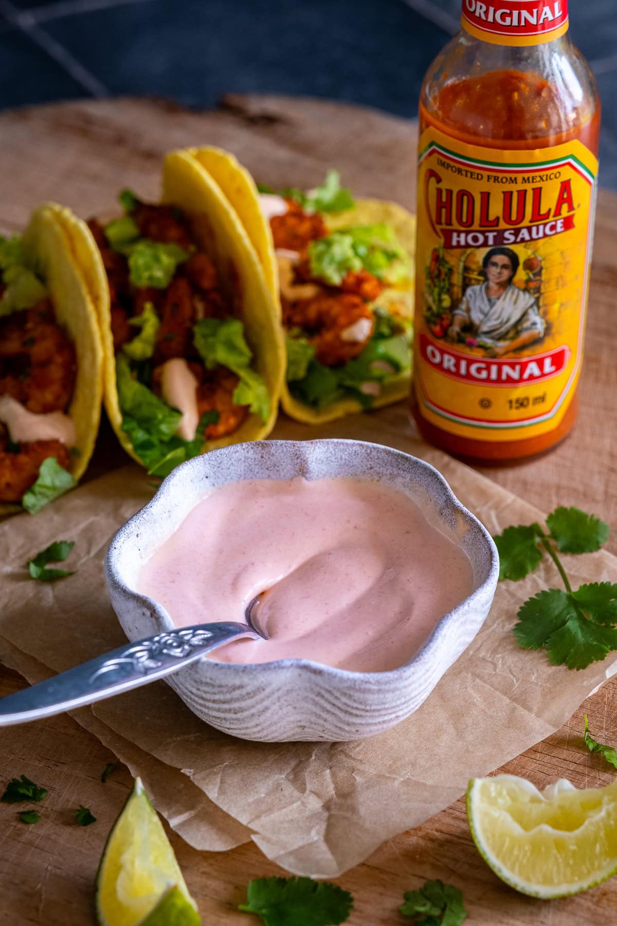 Pink Taco Sauce in a bowl with a bottle of Choula Original Hot Sauce
