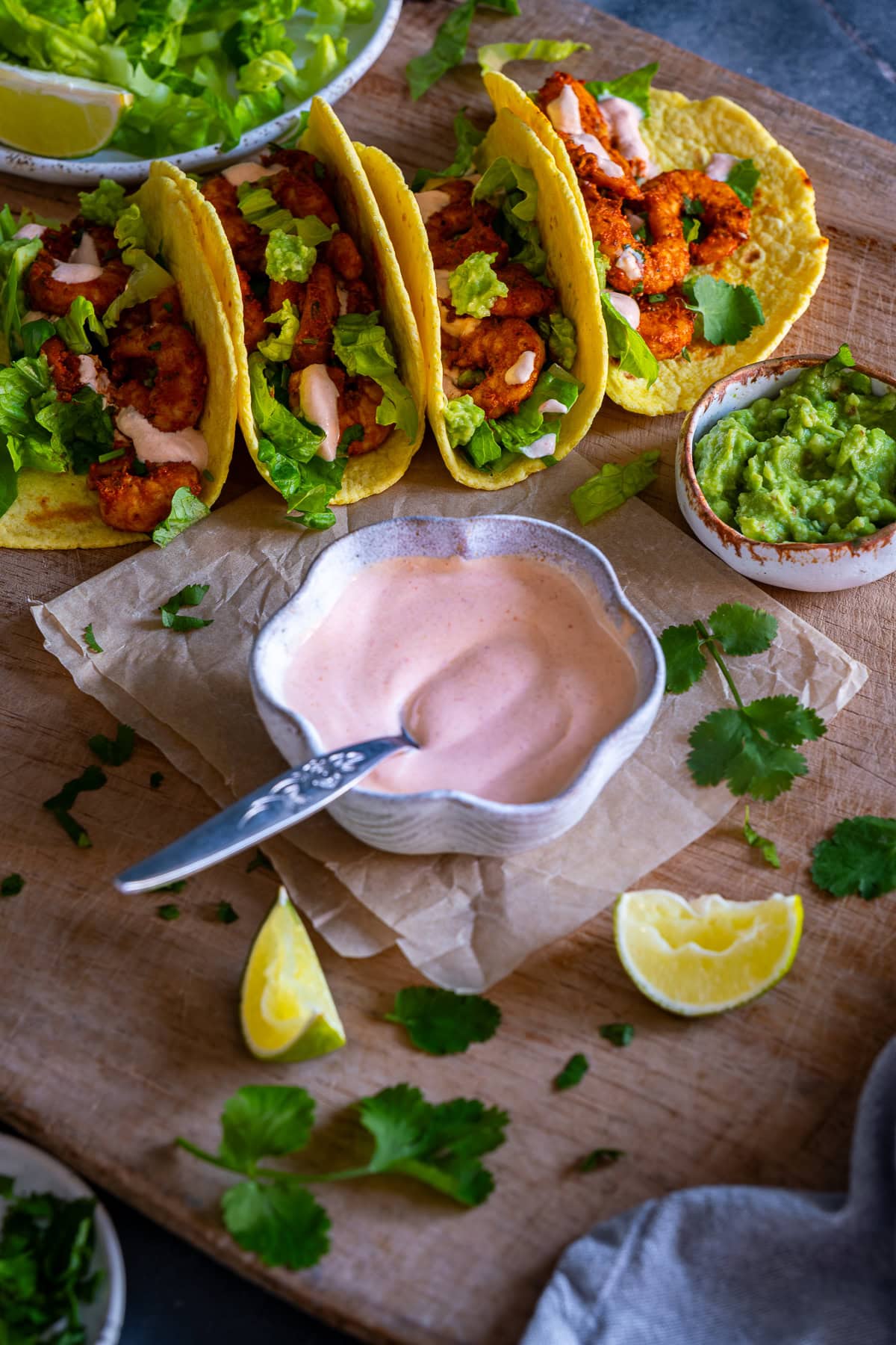 Pink Taco Sauce in a bowl in front of prawn tacos.